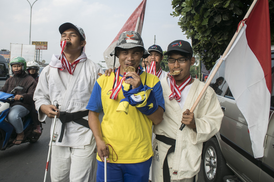 Visually impaired athletes seen walking from Bandung, West Java, to the Gelora Bung Karno Sports Complex in Central Jakarta on Saturday (04/08). They plan to return gold and silver medals they won at the 15th National Paralympic Week to President Joko 'Jokowi' Widodo to protest a mandatory 25 percent deduction by the National Paralympic Committee from cash bonuses they earned for their achievements. (Antara Photo/Novrian Arbi)