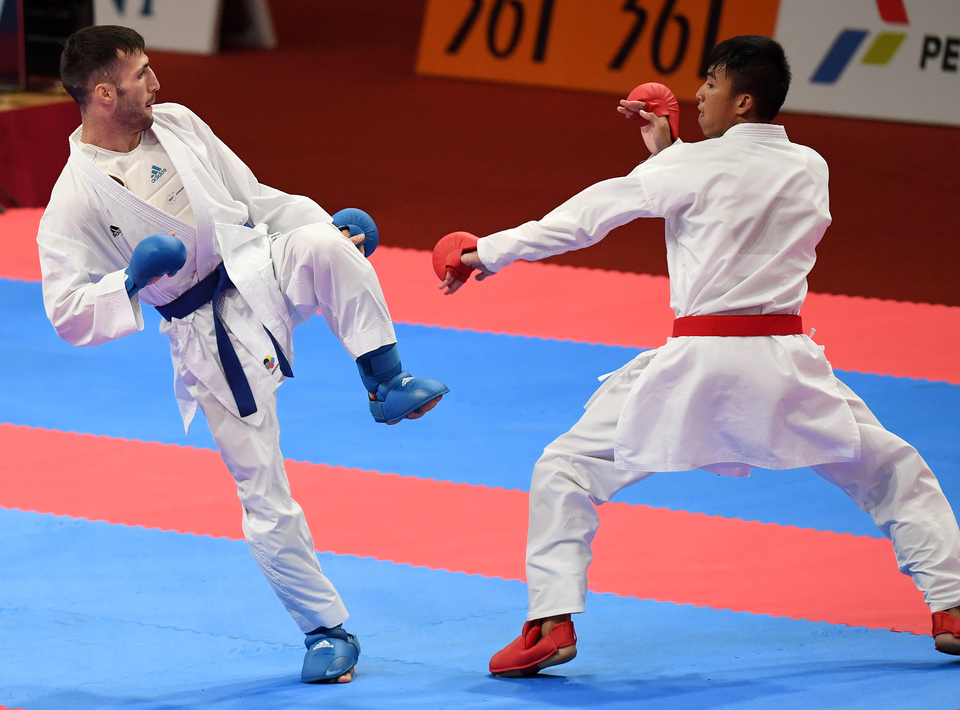 Rifki Ardiansyah Arrosyiid, right, won an 11th gold medal for Indonesia at the 2018 Asian Games by defeating Amir Mahdi Zadeh of Iran in the men's under-60 kilogram kumite final at the Jakarta Convention Center on Sunday afternoon (26/08). (Antara Photo/Inasgoc/Yudhi Ginanjar)