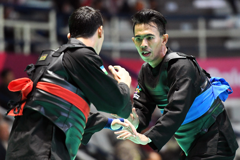 Indonesian pencak silat athlete Amri Rusdana, right, faces Uzbekistan's Nurulla Saidov at an Asian Games's event in Jakarta on Thursday (23/08). (Inasgoc Photo/Dewi Nurcahyani via Antara)