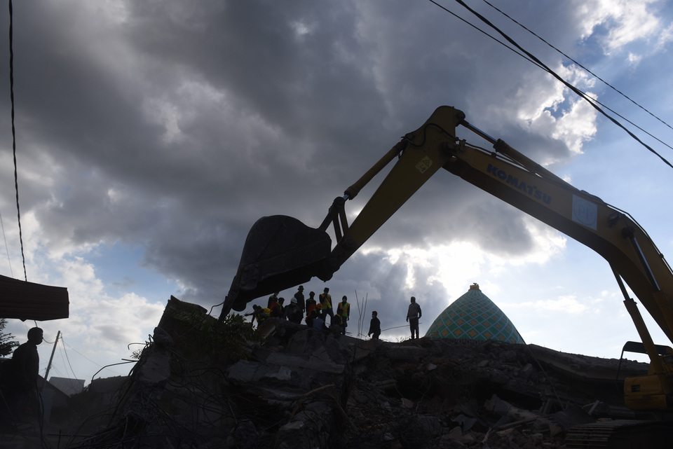 Members of a search team look for victims of last week's earthquake in Pemenang, North Lombok, West Nusa Tenggara, Tuesday (07/08). Dozens of people may still be buried under a mosque building, which collapsed during prayers on Sunday. (Antara Photo/Zabur Karuru)