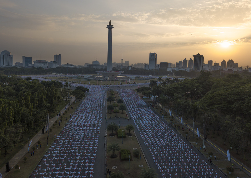 Tens of thousands of people dance the poco-poco at the National Monument complex in Jakarta on Sunday (05/08), to celebrate the upcoming 2018 Asian Games and break a record. (Antara Photo/Akbar Nugroho Gumay)