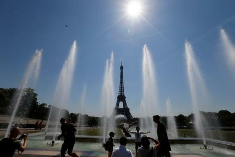 People cool off in the fountains across from the Eiffel Tower as a heatwave with high temperatures continues in Paris, France, Aug. 3. (Reuters Photo/Regis Duvignau)