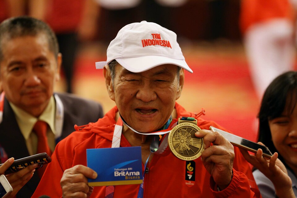 FILE - Billionaire banker and tobacco mogul Michael Bambang Hartono shows his bronze medal from the bridge event of the 2018 Asian Games during a ceremony at the State Palace in Jakarta, Sunday, Sep. 2, 2018. (B-Universe Photo/Joanito De Saojoao)