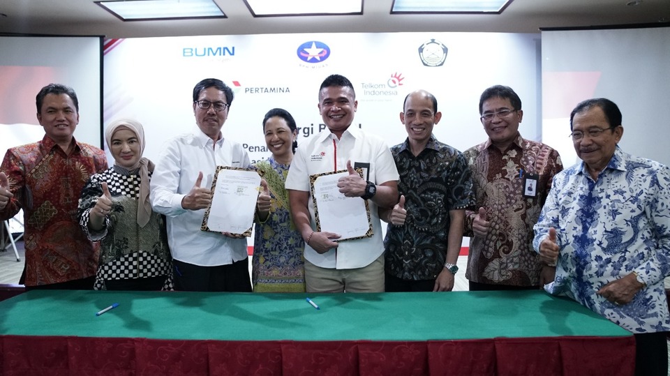 Mas'ud Khamid, third from left, director of retail marketing at Pertamina, and Dian Rachmawan, fourth from right, director of enterprise and business at Telkom, after signing the cooperation agreement in Jakarta on Friday (31/08). (Photo courtesy of Telkom)