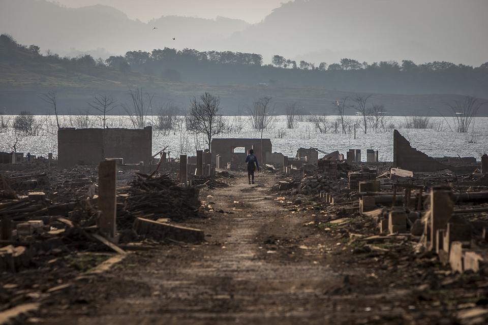 A former resident of Cipaku in Sumedang district, West Java, walks among the ruins of the village, which had been under water for nearly three years. (JG Photo/Yudha Baskoro)