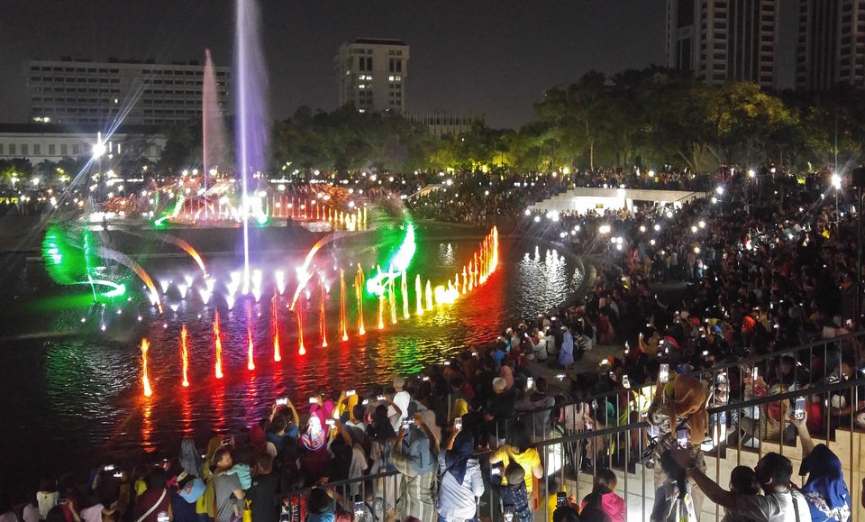 Visitors watching a dancing fountain show at Banteng Square in Central Jakarta on Saturday (08/09). The dancing fountain display accompanies performances of national and regional songs at the square every weekend. (Antara Photo/Fanny Octavianus)