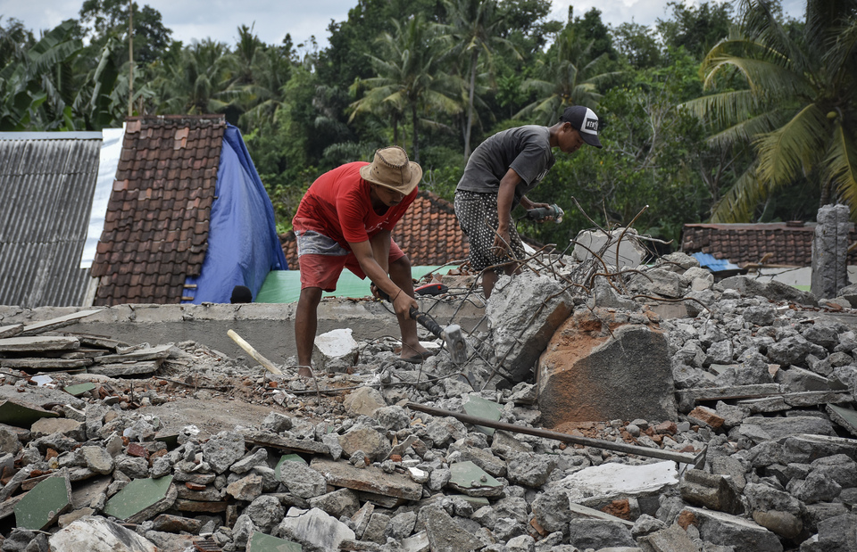 Residents using makeshift tools to clear the rubble of a house in Dopang village, West Lombok, West Nusa Tenggara, on Sept. 5. The house was destroyed in a series of devastating earthquakes that struck the region during August. (Antara Photo/Ahmad Subaidi)