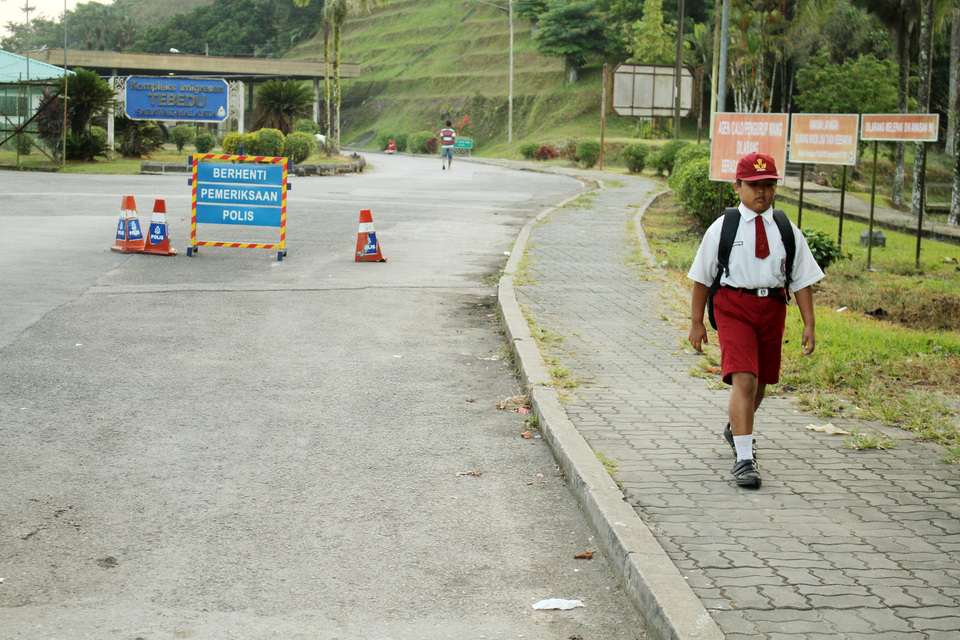Nursaka, an Indonesian boy living in Sarawak, Malaysia, passes the Tebedu-Entikong border post while on his way to Sontas Entikong 03 State Elementary School in Sanggau district, West Kalimantan, on Thursday (13/09). He crosses the border between the two countries at least twice every day. (Antara Photo/HS Putra)