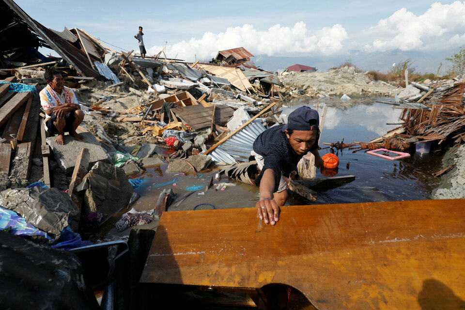 A man searches for his family's belongings in the remains of their home in Petobo, Central Sulawesi, following last month's devastating earthquake and tsunami. (Reuters Photo/Darren Whiteside)