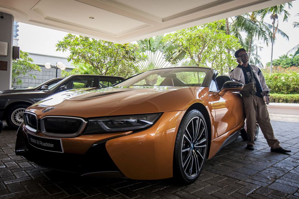 German luxury automaker BMW unveiled the latest version of its plug-in hybrid sports car, the i8 Roadster, at Shangri-La Hotel in Central Jakarta on Wednesday. The two-seater is fitted with a turbocharged 1.5-liter three-cylinder petrol engine and electric motor in the rear, plus another electric motor and battery in front, which allow the car to accelerate from 0 to 100 kilometers per hour in 4.6 seconds. The company claims average fuel consumption of 2.1 liters per 100 kilometers, average power consumption of 14.5 kilowatt-hours per 100 kilometers and average carbon dioxide emissions of 46 grams per kilometer. (JG Photo/Yudha Baskoro)
