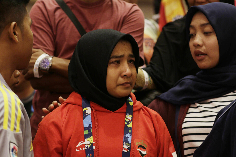 Indonesian judoka Miftahul Jannah, center, was disqualified from the 2018 Asian Para Games on Monday for refusing to remove her hijab, which, under rules set by several international sports governing bodies, she is not allowed to wear during competitions. (Antara Photo/M Iqbal Ichsan)