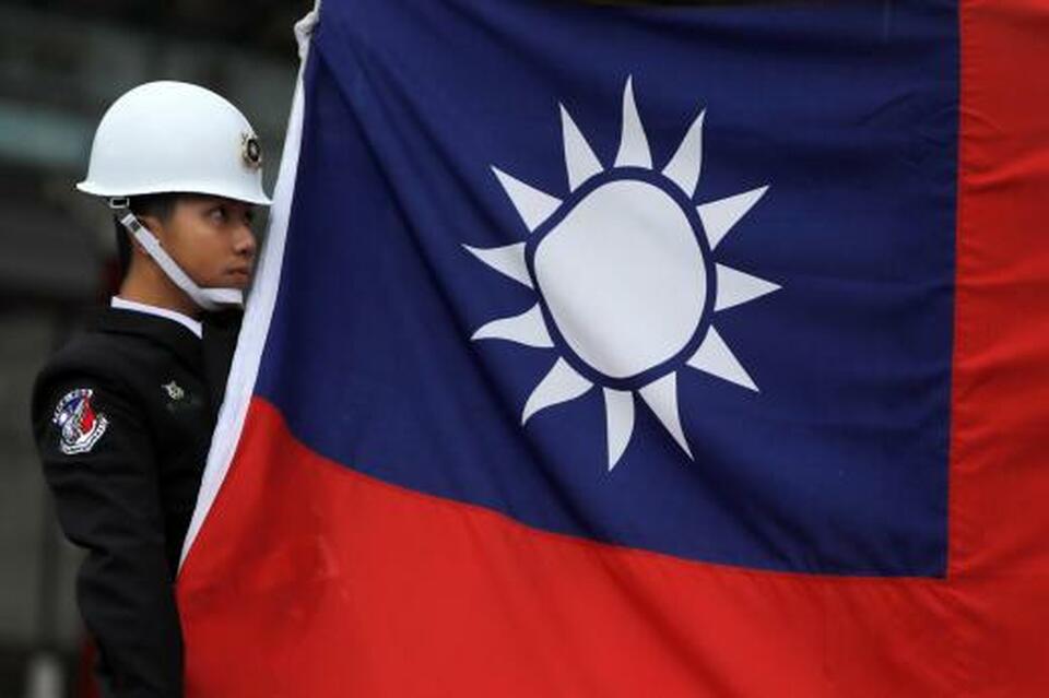 A military honor guard holds a Taiwanese national flag as he attending flag-raising ceremony at Chiang Kai-shek Memorial Hall, in Taipei, Taiwan on March 16, 2018. (Reuters Photo/Tyrone Siu)