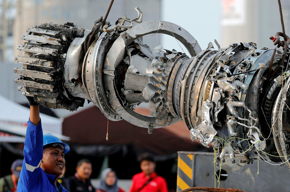A worker assists his colleague during the lifting of a turbine engine of the Lion Air flight JT-610 jet, at Tanjung Priok Port in North Jakarta on Sunday (Reuters Photo/Beawiharta)