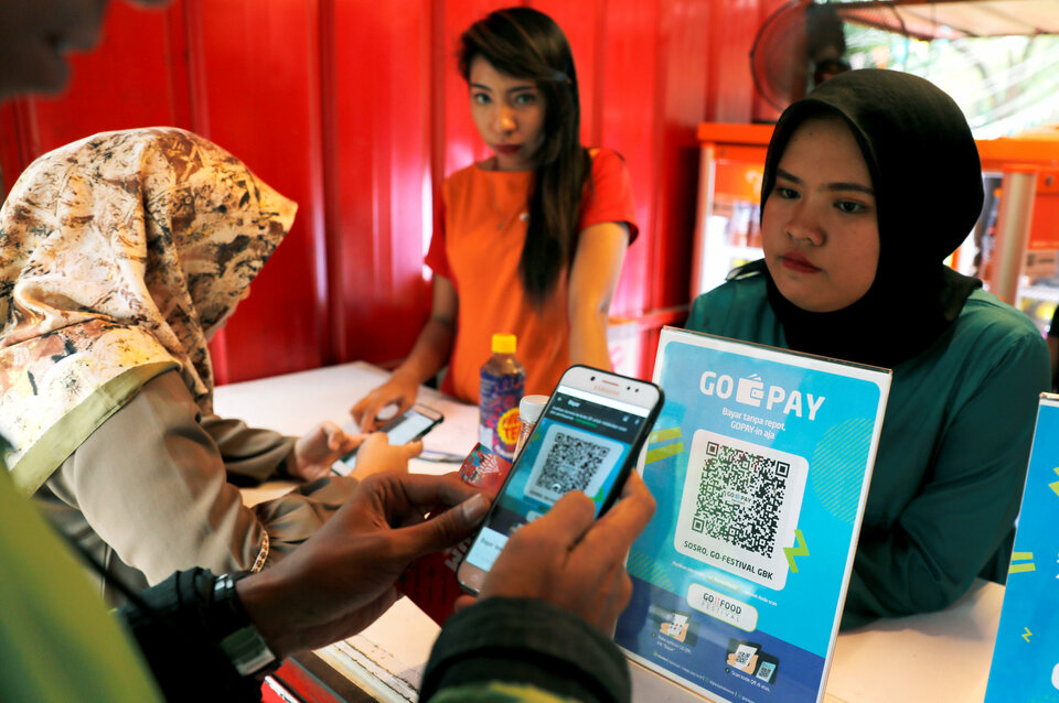 A customer uses a smartphone to scan code during pay food using Go Pay at a food counter during Go-Food festival in Jakarta, Indonesia, October 27, 2018. Picture taken October 27, 2018. REUTERS/Beawiharta