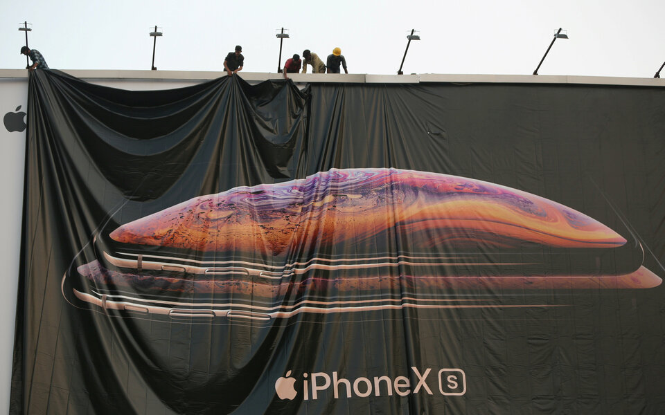 Workers adjust a hoarding of the newly launched iPhone XS in Ahmedabad, India. (Reuters Photo/Amit Dave)
