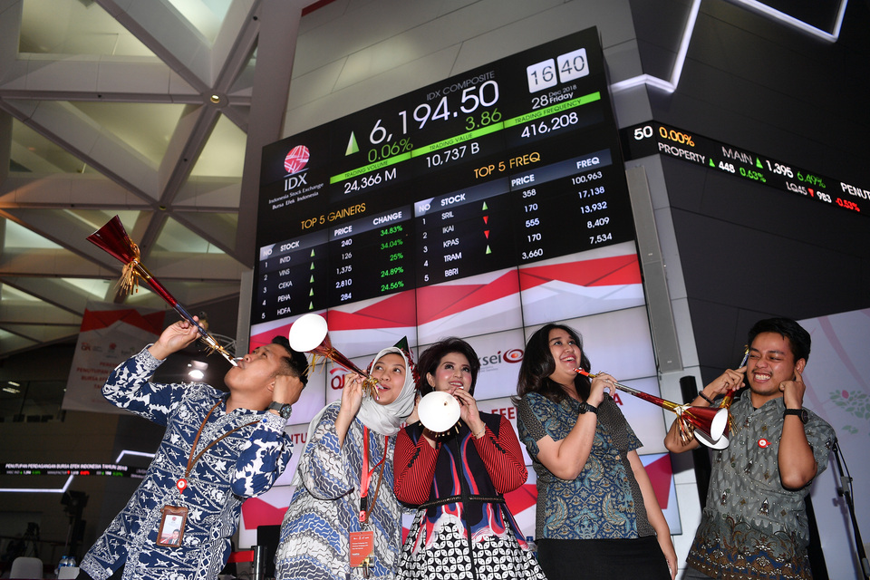 A number of employees at the Indonesia Stock Exchange blew trumpet to mark the end of trading day in 2018. (Antara Photo/Sigid Kurniawan)