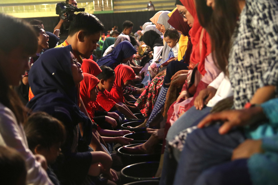 Sejumlah anak membasuh kaki ibunya saat prosesi sungkem masal yang diselenggarakan oleh Dinas Kebudayaan Pariwisata Kepemuda dan Olah Raga di Gor Jayabaya, Kota Kediri, Jawa Timur, Sabtu (22/12/2018) malam. Kegiatan membasuh kaki dan sungkem tersebut diikuti oleh sedikitnya seratus pasang ibu-anak guna memperingati Hari Ibu. ANTARA FOTO/Prasetia Fauzani/hp.
