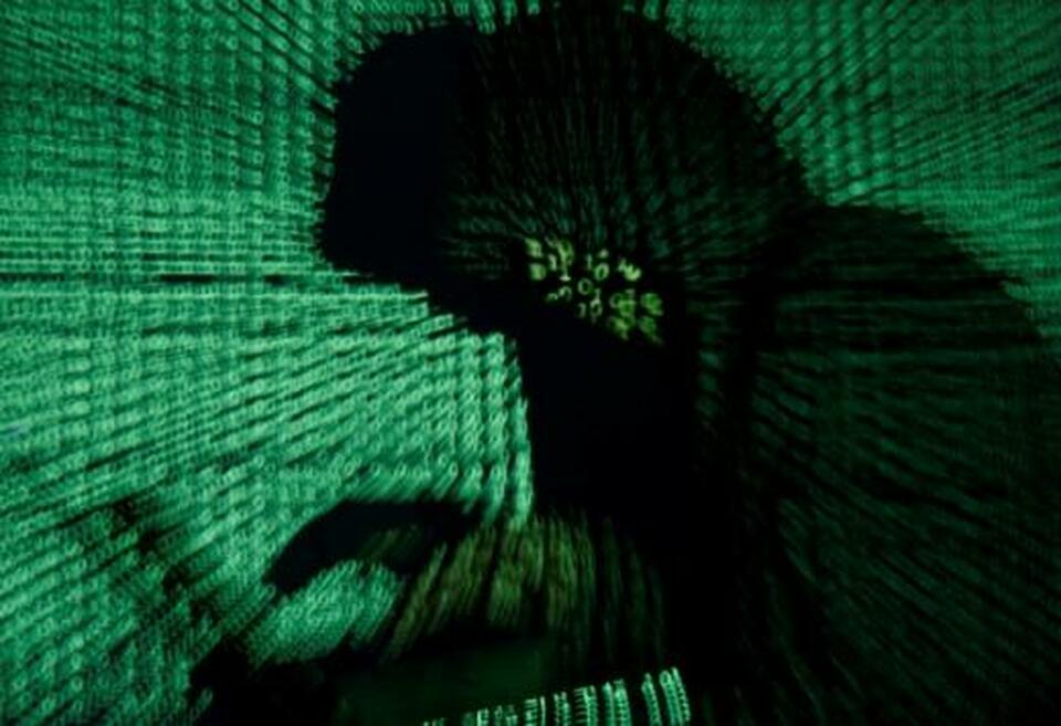 A man holds a laptop computer as cyber code is projected on him in this illustration picture taken on May 13, 2017. (Reuters Photo/Kacper Pempel)