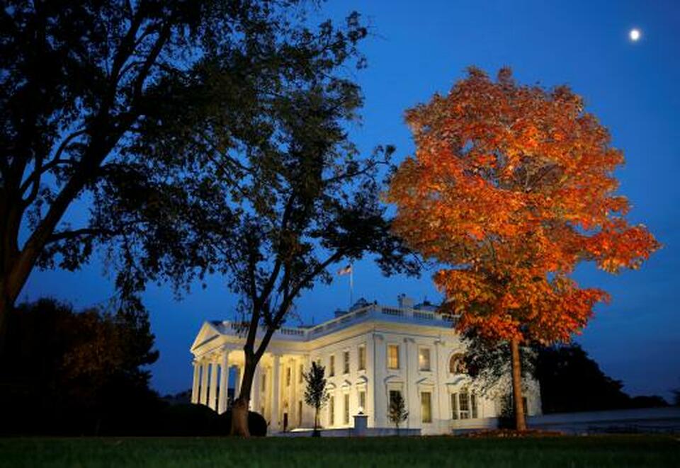 A tree is awash in autumn color as the moon rises over the White House on election night in Washington. (Reuters Photo/Kevin Lamarque)