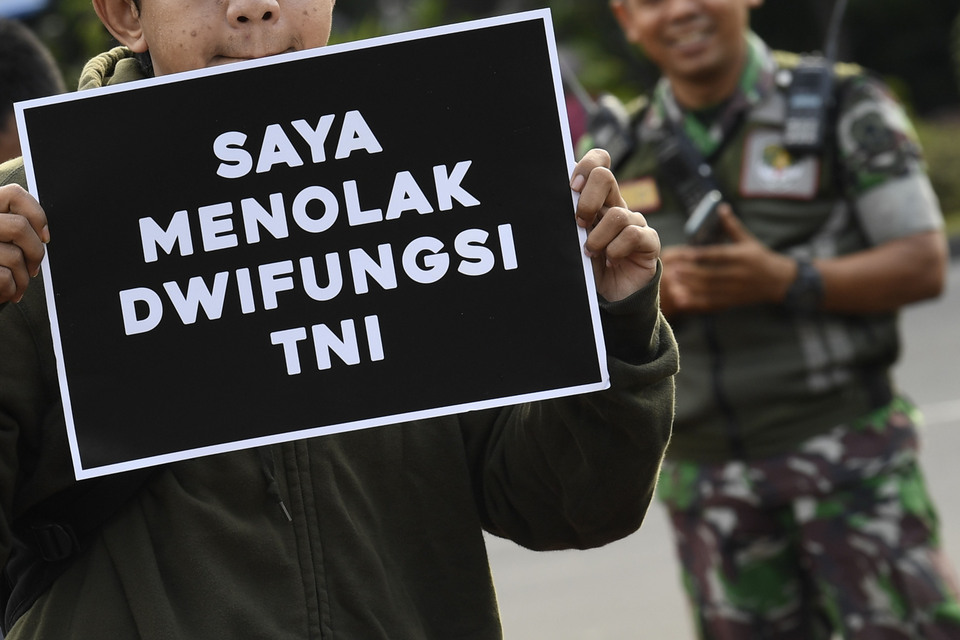 'I Stand Against Dual Function of the Indonesian Military,' says a placard carried by a protester in front of the State Palace in Jakarta last Thursday, Feb. 28. (Antara Photo/Puspa Perwitasari)