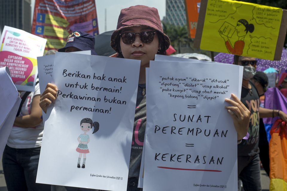 A demonstrator carried a poster stating his disapproval of the practice of child marriage and female circumcision in Gambir, Central Jakarta on Friday (08/03) Female circumcision aims to eliminate sexual sensitivity in women. (JG Photo/Yudha Baskoro)