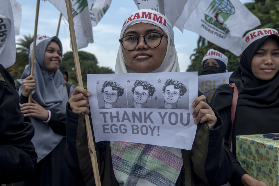 A woman holds up a poster of 'Egg Boy' in Jakarta on Friday (22/03). (JG Photo/Yudha Baskoro)