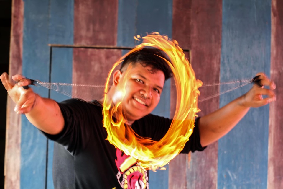 A 'fire poi' artist in Lhokseumawe, Aceh, on Sunday (07/04). (Antara Photo/Rahmad)