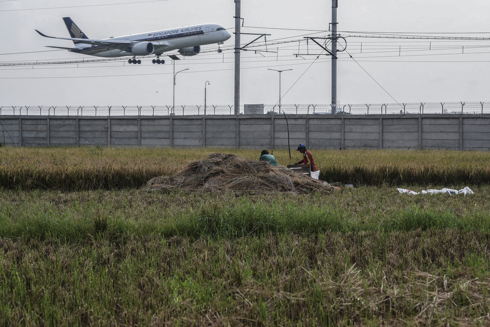 Farmers harvest a rice field near Sukarno-Hatta International Airport in Tangerang, Banten, on Thursday (18/04). (Antara Foto/Muhammad Adjimaja)