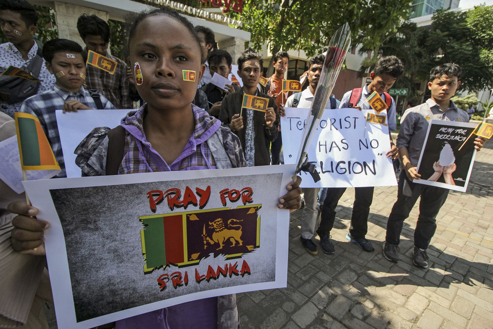 Students hold up posters during a solidarity action for victims of the Easter Sunday bomb attacks in Sri Lanka in Surabaya, East Java, on Monday (22/04). (Antara Photo/Moch. Asim)