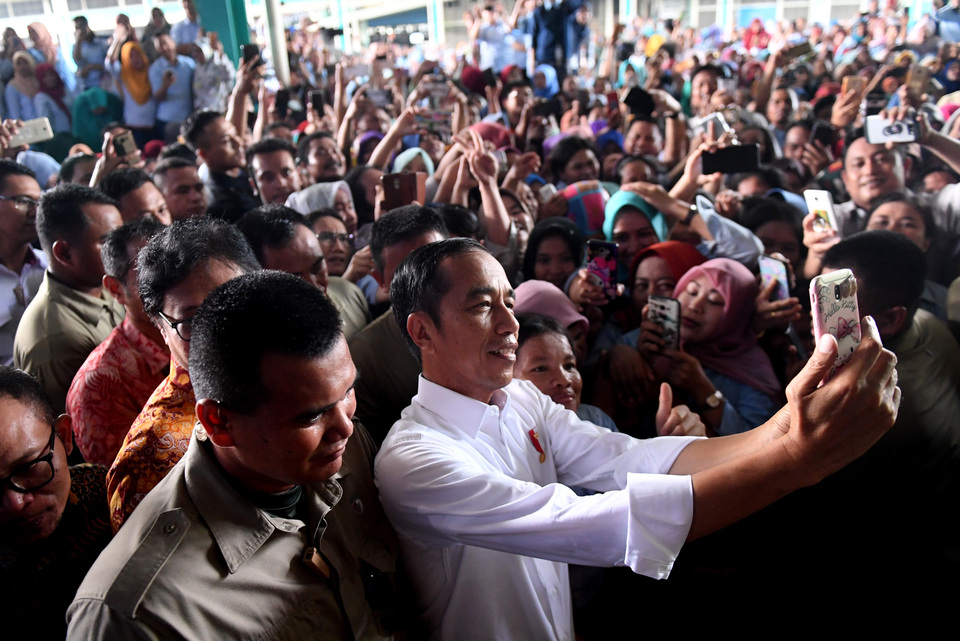 President Joko 'Jokowi' Widodo takes a selfie with his fans. (Antara Photo/Akbar Nugroho Gumay)