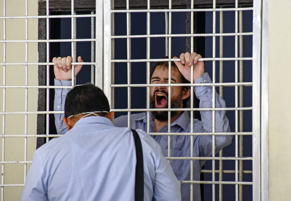 French national Dorfin Felix, right, speaks to his lawyer from behind bars after being convicted of drug offense and sentenced to death at the Mataram District Court, West Nusa Tenggara, on May 20, 2019.  Prosecutors have earlier recommended a sentence of 20 years in prison. (Antara Photo/Ahmad Subaidi)