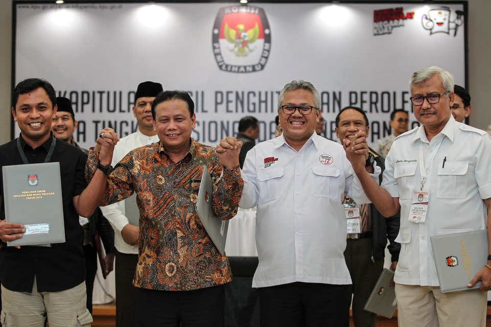 Chief commissioner of the General Elections Commission (KPU) Arief Budiman, second from right, with the head of the Election Monitoring Agency (Bawaslu) Abhan, second from left, at the KPU office early on Tuesday morning. (Antara Photo/Dhemas Reviyanto)