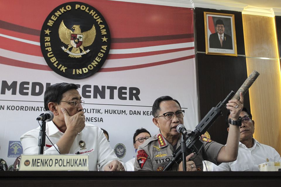 National Police chief Gen. Tito Karnavian displays a rifle and silencer confiscated by security forces. (Antara Photo/Dhemas Reviyanto)