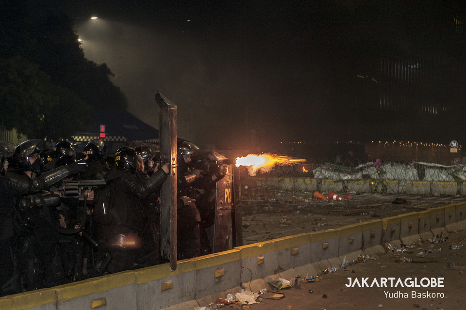 A police mobile brigade officer shoots from his flare gun during a riot in Central Jakarta on May 22. (JG Photo/Yudha Baskoro)