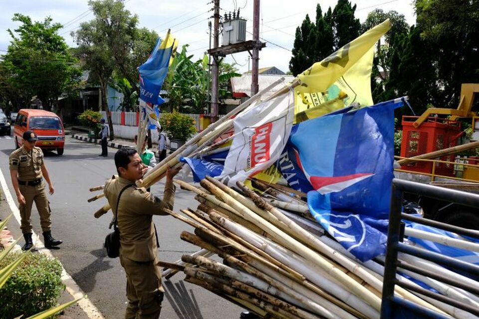 Members of the municipal police (Satpol PP) removing campaign paraphernalia from public spaces in Temanggung district, Central Java. The Election Supervisory Agency (Bawaslu) said nine of the 16 political parties that contested last month's legislative election did not fully report the identities of their campaign contributors. (Antara Photo/Anis Efizudin)