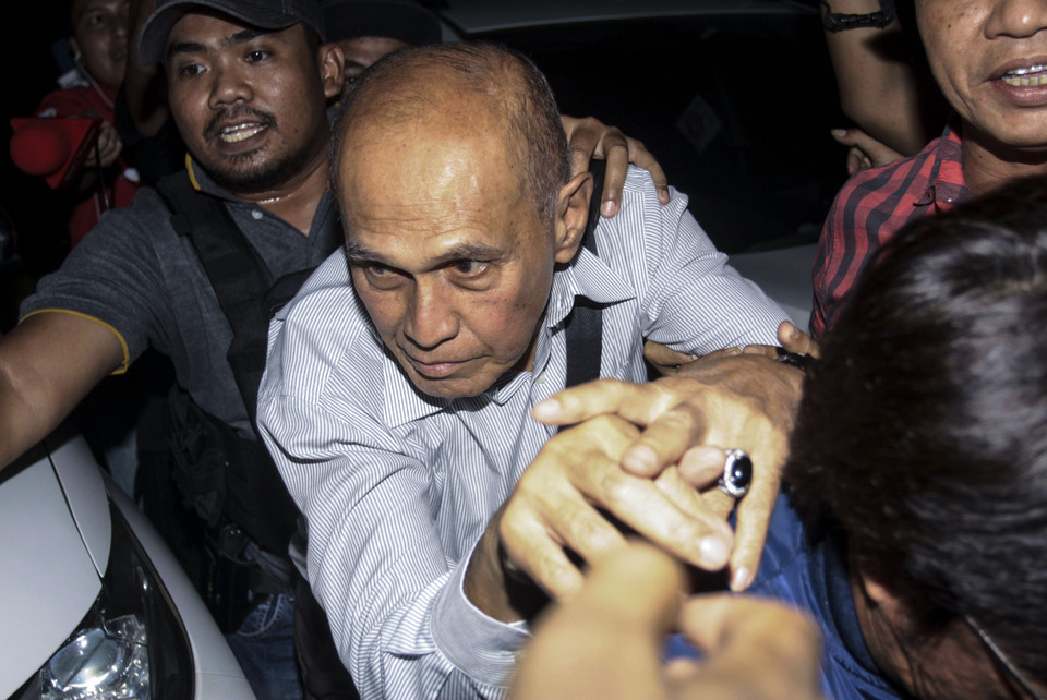 Retired Army general Kivlan Zen, center, being escorted by police investigators to the detention barracks of the Military Police in South Jakarta on Thursday evening. (Antara Photo/Reno Esnir)
