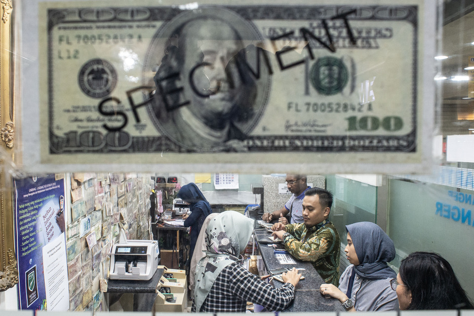 Customers buy foreign currencies at a money changer in Jakarta, Wednesday, May 15, 2019. (Antara Photo/Aprillio Akbar)/