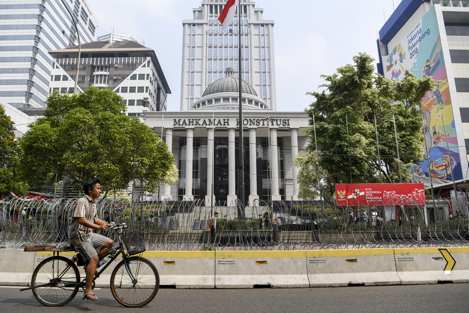A man rides his bicycle in front of the Constitutional Court building in Central Jakarta on June 24, 2019. (Antara Photo/Hafidz Mubarak)