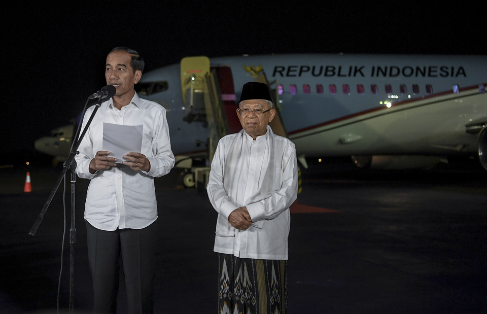 President Joko 'Jokowi' Widodo, accompanied by Vice President-elect Ma'ruf Amin, issues a statement following a Constitutional Court ruling upholding the result of this year's election, at Halim Air Force Base in East Jakarta on Thursday night. (Antara Photo/Wahyu Putro A.)