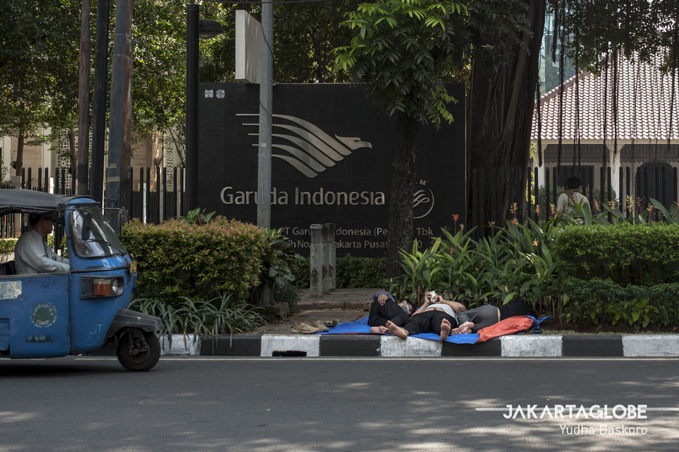 A Bajaj passes a group of refugees camped out in front of Garuda Indonesia's office on Jalan Kebon Sirih in Central Jakarta in July this year. (JG Photo/Yudha Baskoro)