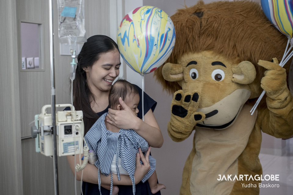 An entertainer dressed in a lion costume offers a balloon to a ch patient at Siloam Hospitals Asri in South Jakarta on National Children's Day on Tuesday. (JG Photo/Yudha Baskoro)