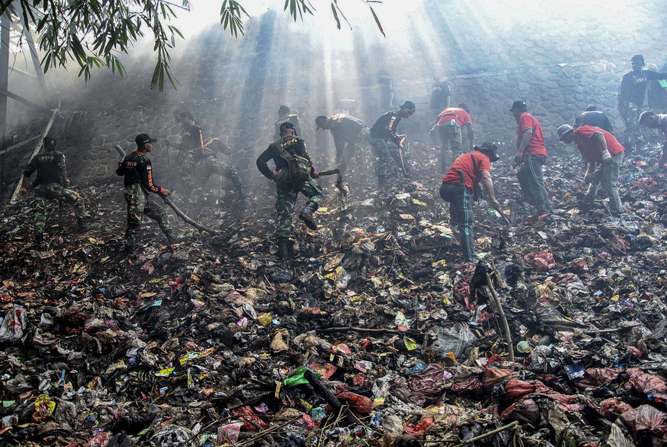 Army soldiers clean up trash at Cisadane River in Bogor, West Java, on Tuesday. (Antara Photo/Arif Firmansyah)