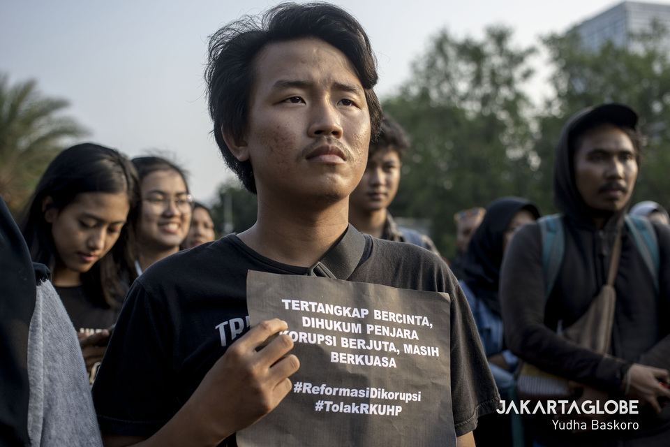A protester holds up an anti-corruption pamphlet during a Kamisan protest in front of the State Palace in Jakarta last year. (JG Photo/Yudha Baskoro)