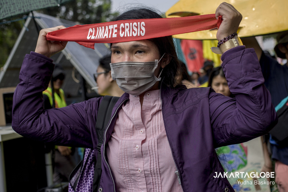 A protester puts on her headband before marching to the State Palace. (JG Photo/Yudha Baskoro)