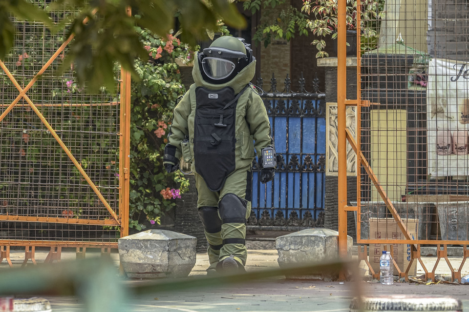 A member of the National Police's bomb disposal team returns after preparing to detonate an improvised explosive device found in the home of a terror suspect in Semper Barat village in Cilincing, North Jakarta, on Monday. (Antara Photo/Muhammad Adimaja)
