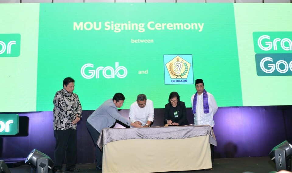 Transportation Minister Budi Karya Sumadi, right, witnesses the signing of a cooperation agreement by Grab Indonesia and the Indonesian Association for the Welfare of the Deaf (Gerkatin) in Jakarta on Tuesday. (Photo courtesy of the Ministry of Transportation)