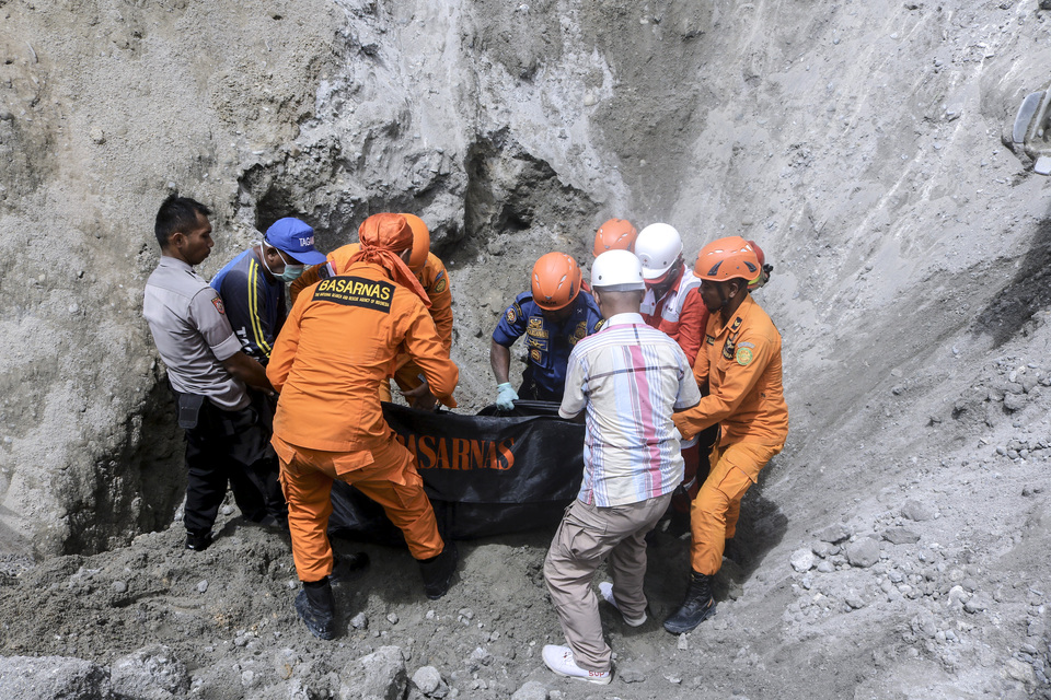 Search and rescue team evacuated the body of Matheis Frans, a resident of Nania village who was buried in a sand dune after a 6.5-magnitude earthquake hit Ambon in Maluku on Thursday. (Antara Photo/Izaac Mulyawan)