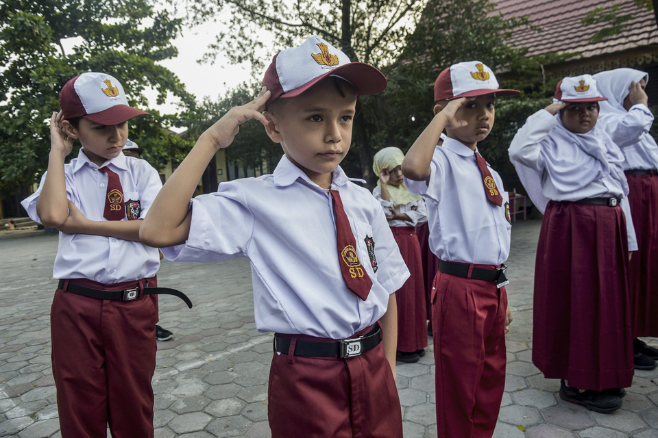 Migrant children salute the Indonesian flag during a ceremony at an elementary school in Pekanbaru, Riau, on Monday. Eighty-one children of asylum seekers and refugees from various parts of the world have been admitted to public schools in the city. Like their Indonesian counterparts, they attend the traditional Monday ceremony, during which they are taught discipline and respect for their host country. (Antara Photo/FB Anggoro)