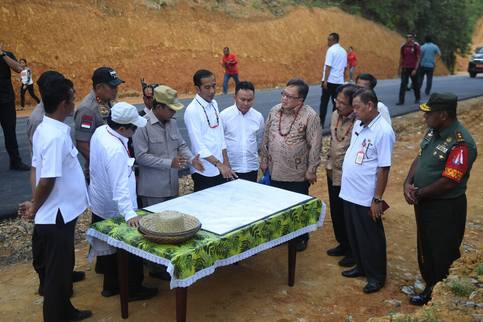 President Joko Widodo, center, looks at a map during his visit to Central Kalimantan in May to search for the location of Indonesia's new capital. (Antara Photo/Akbar Nugroho Gumay)