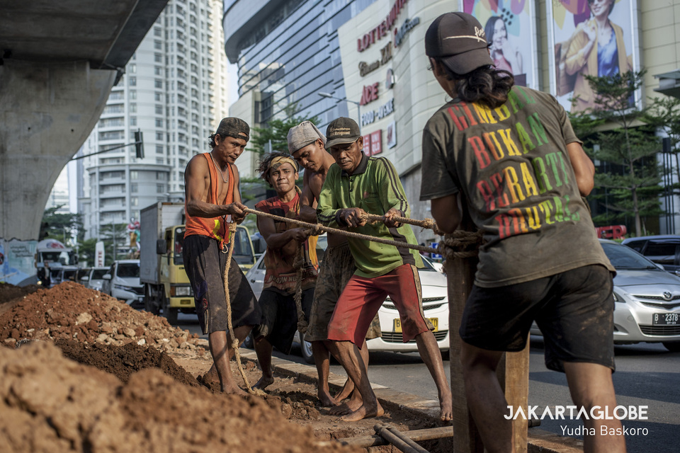 Men seen working on the construction of a new pedestrian walkway under the Casablanca overpass in front of Lotte Shopping Avenue on Jalan Prof. Dr. Satrio in Kuningan, South Jakarta, on Friday. (JG Photo/Yudha Baskoro)